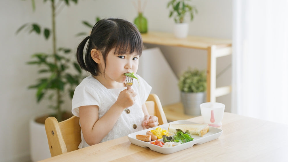 Asian child eating in the living room