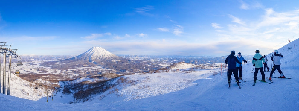 Skiers seeing a snowy volcano in late afternoon (Niseko, Hokkaido, Japan)