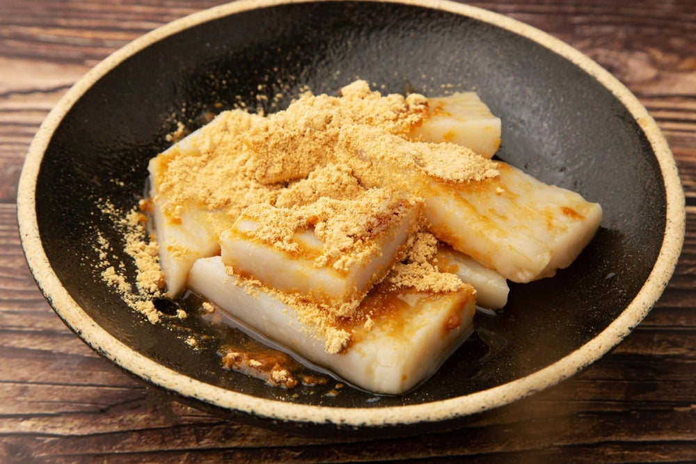 A bowl of kuzumochi topped with kinako roasted soybean flour.